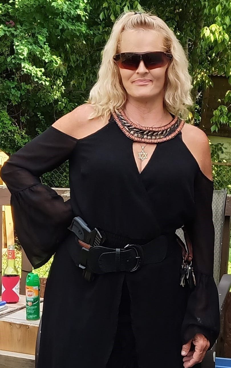 A gold pen beside three small bottles of liquid in pink and beige.